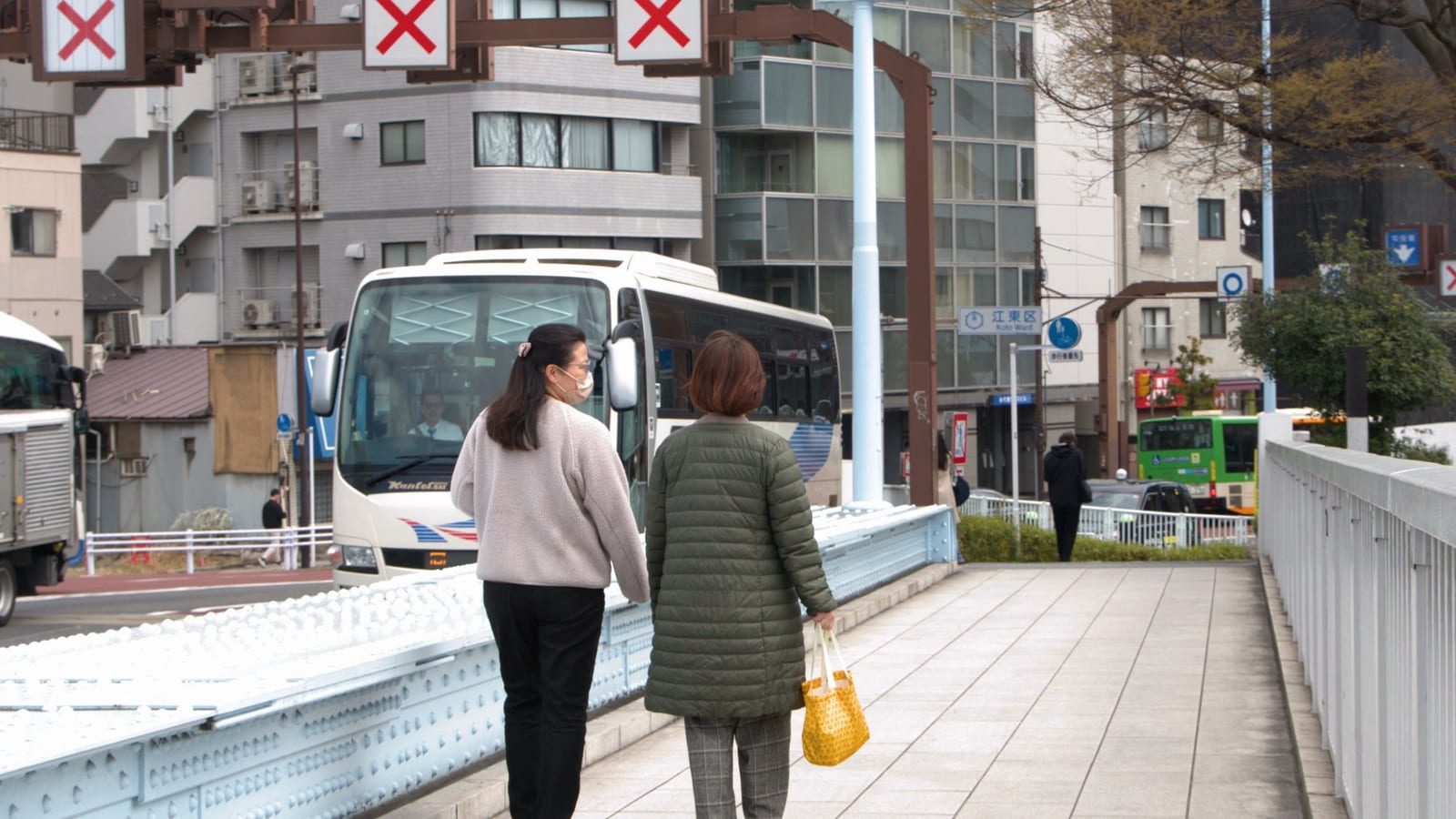 高架道路脇で自転車を押す岩国市内の女性